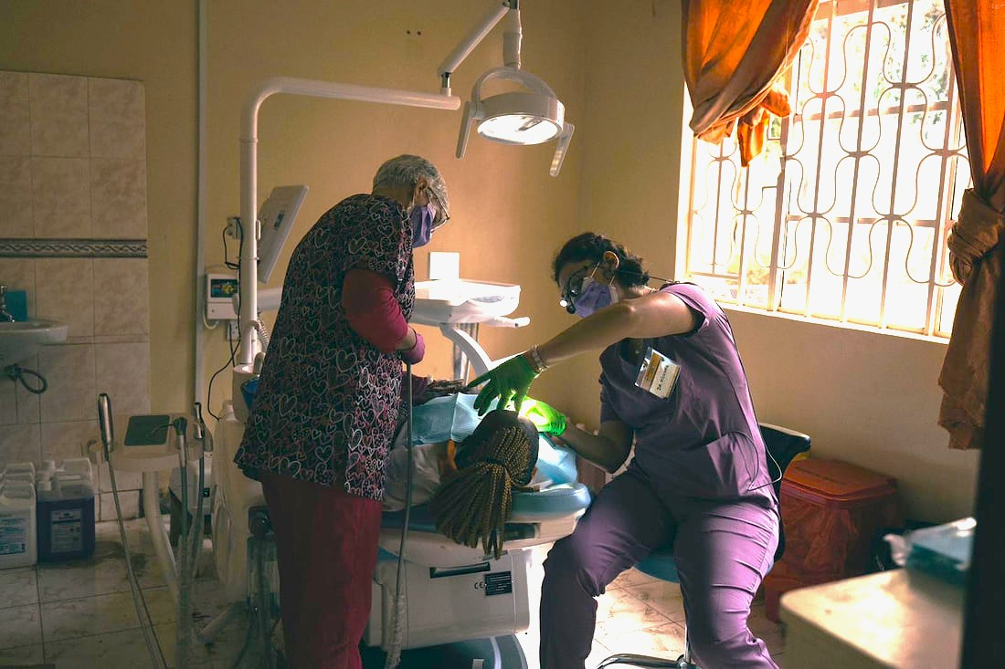 Two dentists assist a patient in Kenya